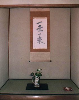 長野烈氏席，化生庵の床にはドイツ製のジョッキを花生にして，花の八手花笠が飾られた。